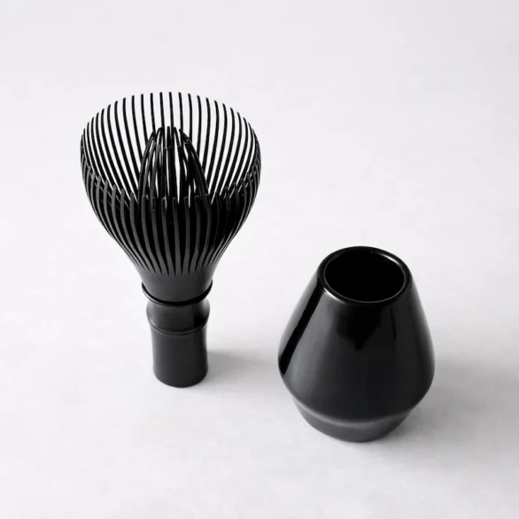 Fouet à matcha en résine noire avec support assorti, design minimaliste, présenté comme un ensemble fonctionnel pour le séchage et le maintien de la forme du fouet.