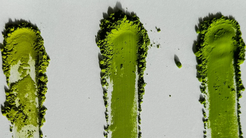 Comparison of three ceremonial matcha powders, with MUSUBI MATCHA Okumidori on the right showing the deepest green and finest texture