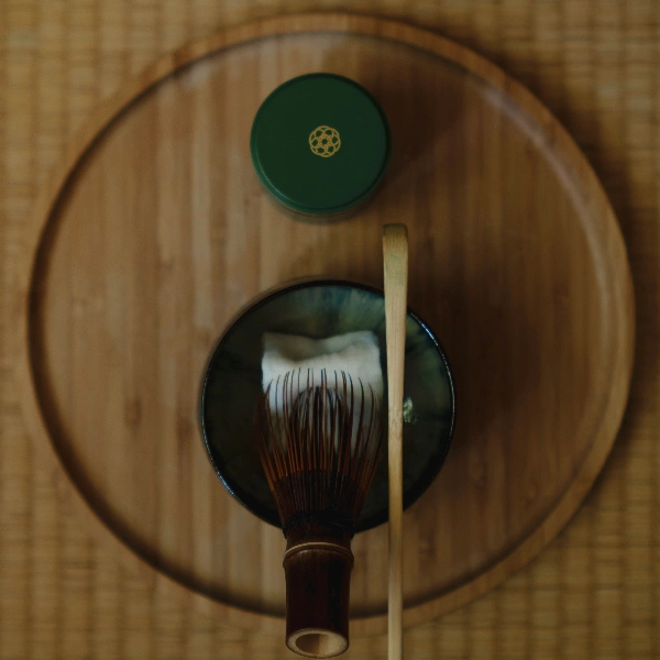 Organic ceremonial matcha being sifted through a fine stainless steel tea strainer, prepared with care for traditional matcha making